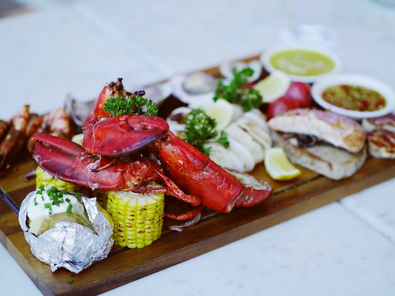 Tabla de mariscos de Summer: langosta, camarón y pescado recién salidos de la plancha